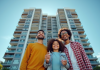 Famille souriante devant un immeuble moderne avec clés
