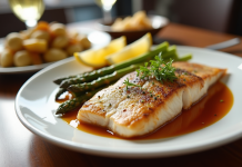 Filet de poisson cuit sur assiette blanche avec légumes colorés
