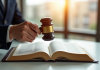 Main de juge avec maillet sur un livre de droit